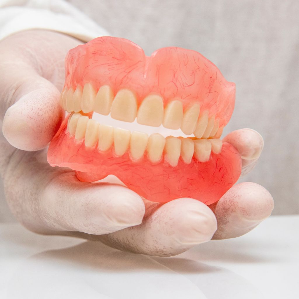 Hand holding a denture